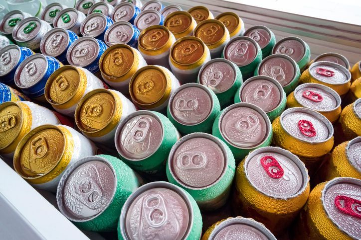 Beer cans Fresh from the fridge. Lots of aluminum cans in the ice in the open fridge. Drops of water on a cold can of drink
