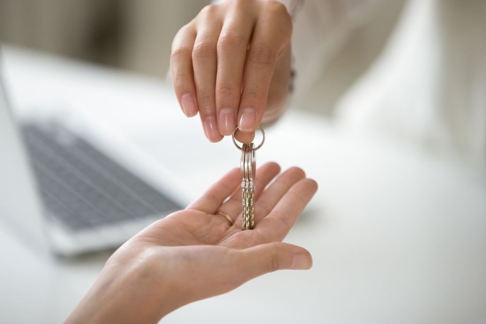 One Person Hands a Set of Keys to Another Person — Richardson Conveyancing In Tumbi Umbi, NSW