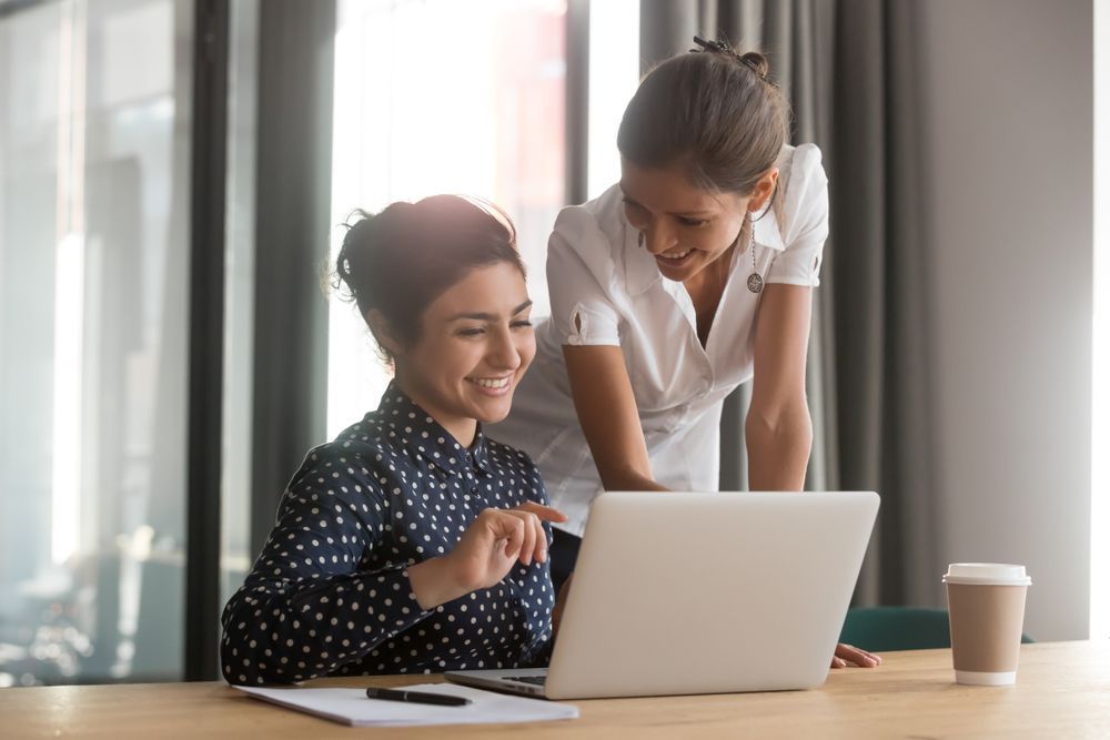 Two Colleagues Looking at a Laptop — Richardson Conveyancing In Tumbi Umbi, NSW