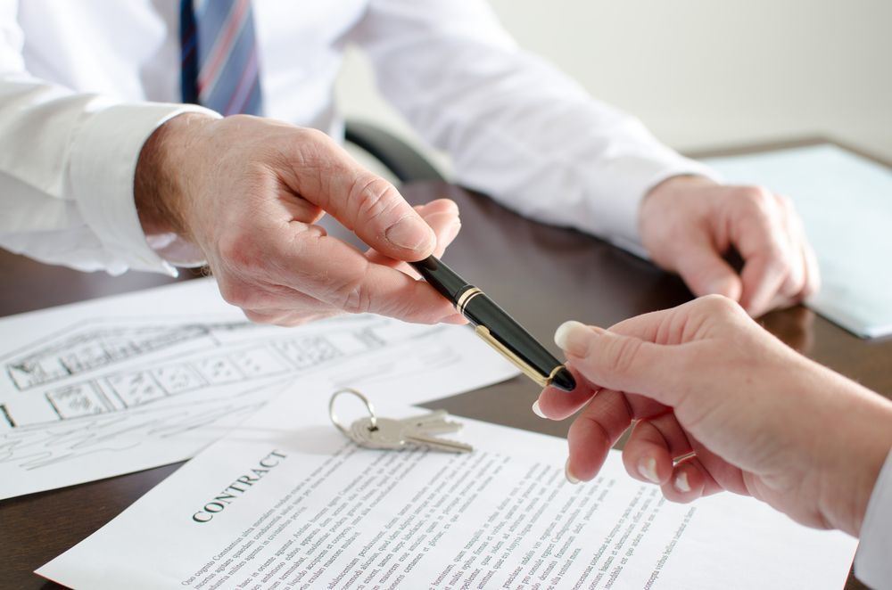 A Person Hands a Pen to Another to Sign a Contract — Richardson Conveyancing In Mudgee, NSW