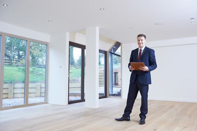 A Real Estate Professional in a Suit Holds a Folder While Standing in a Bright — Richardson Conveyancing In Tumbi Umbi, NSW