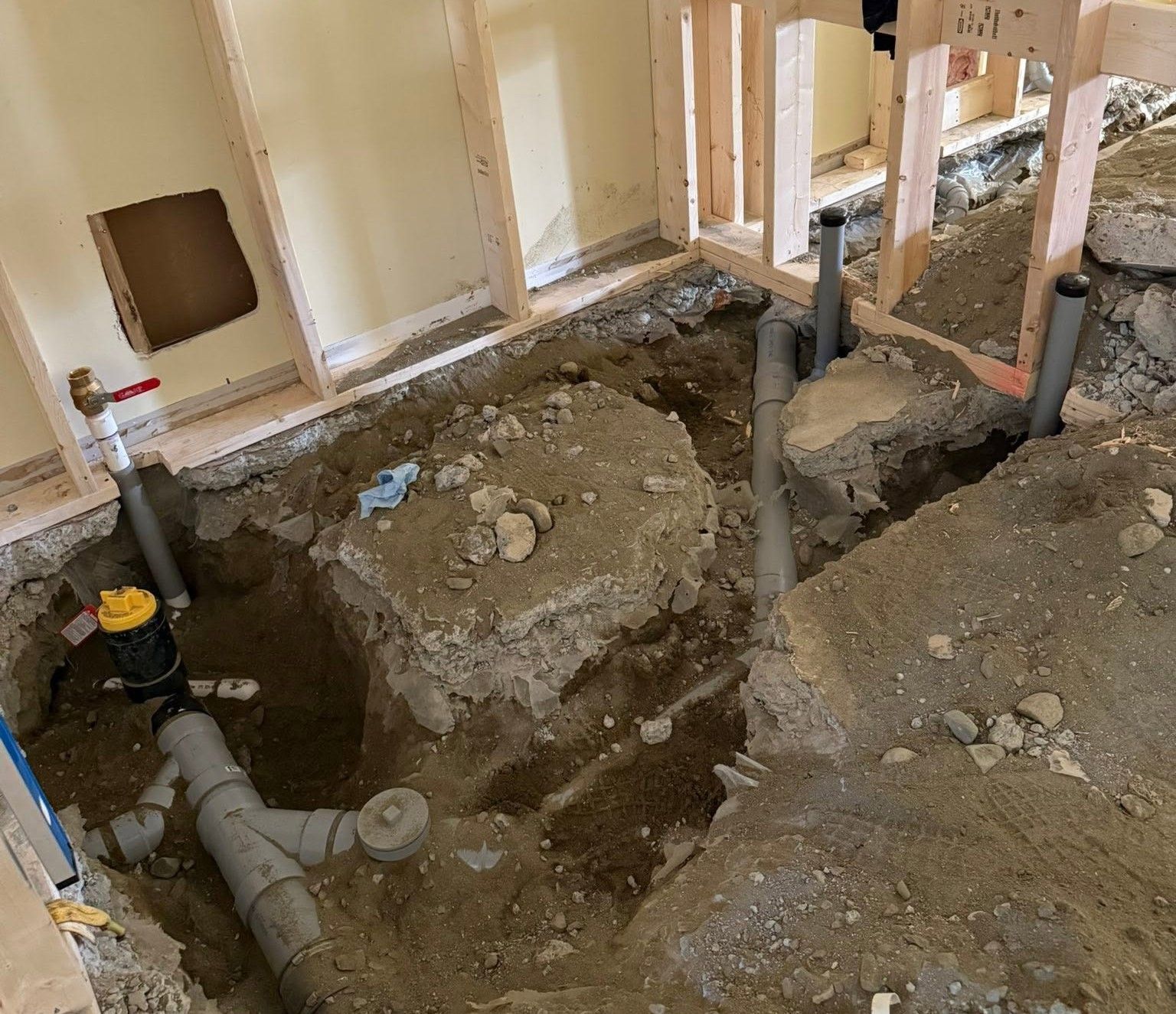 Construction trench and exposed plumbing pipes in a house during renovation