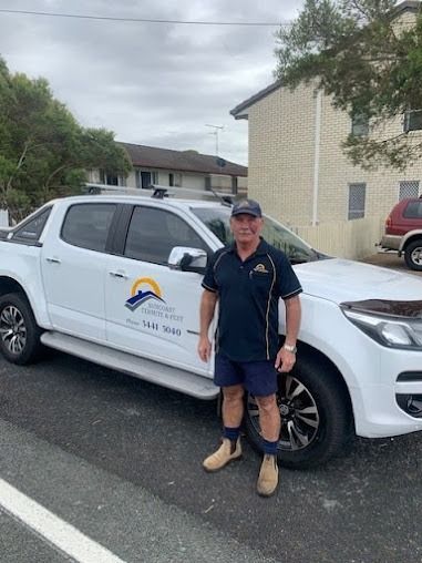 A Man Is Standing In Front Of A White Truck — Suncoast Termite & Pest In Nambour, QLD