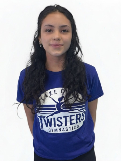 A young woman wearing a blue shirt with the word wild on it is smiling for the camera.