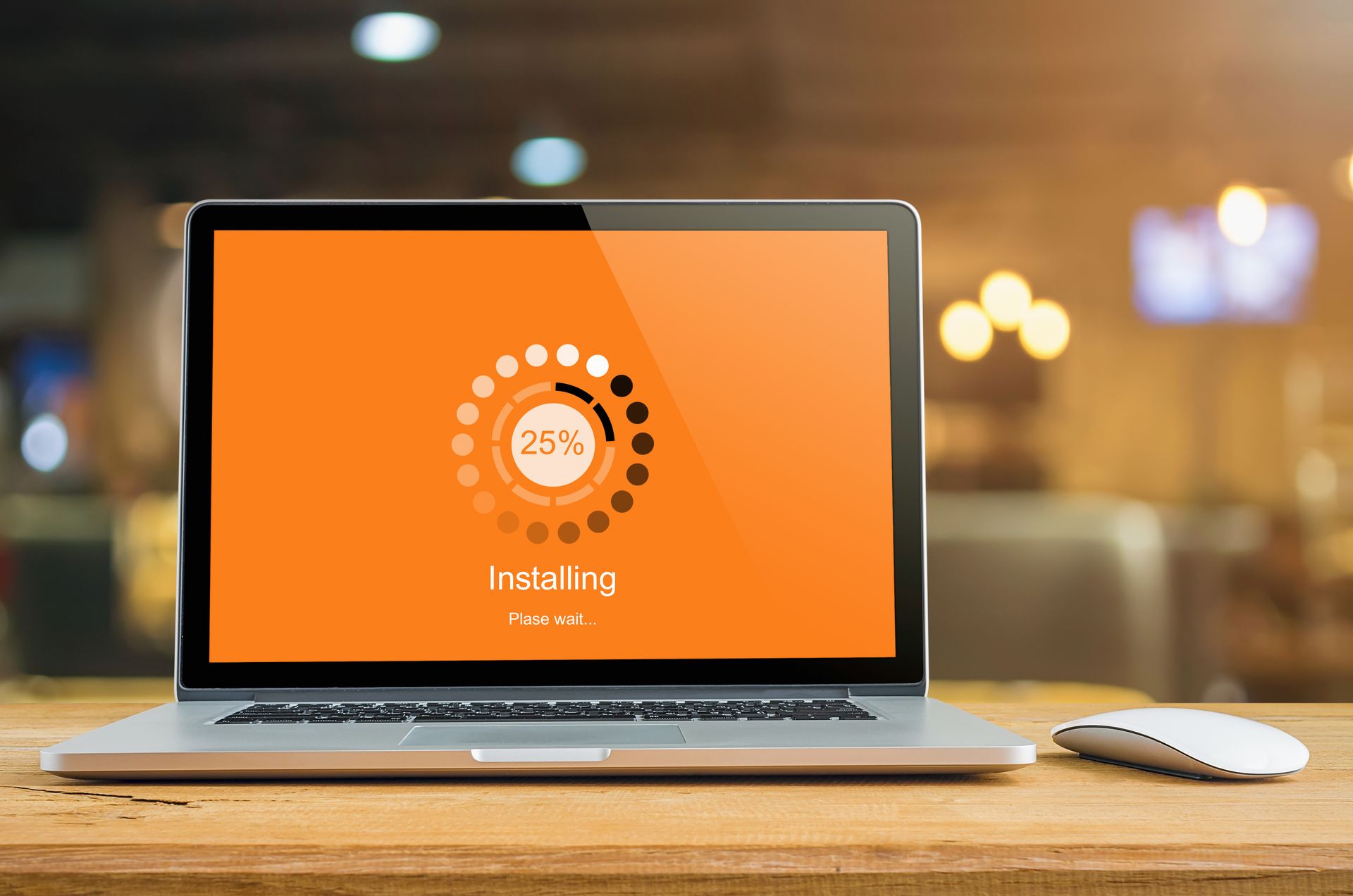 Laptop screen displaying installation progress, at 25%, on a wooden desk.
