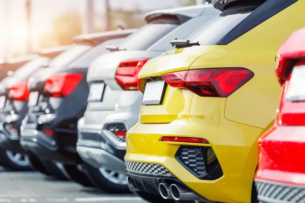 A row of cars parked in a lot, focusing on the rear ends of a yellow vehicle and a red vehicle in the foreground. — Murwillumbah Motor Wreckers in South Murwillumbah, NSW