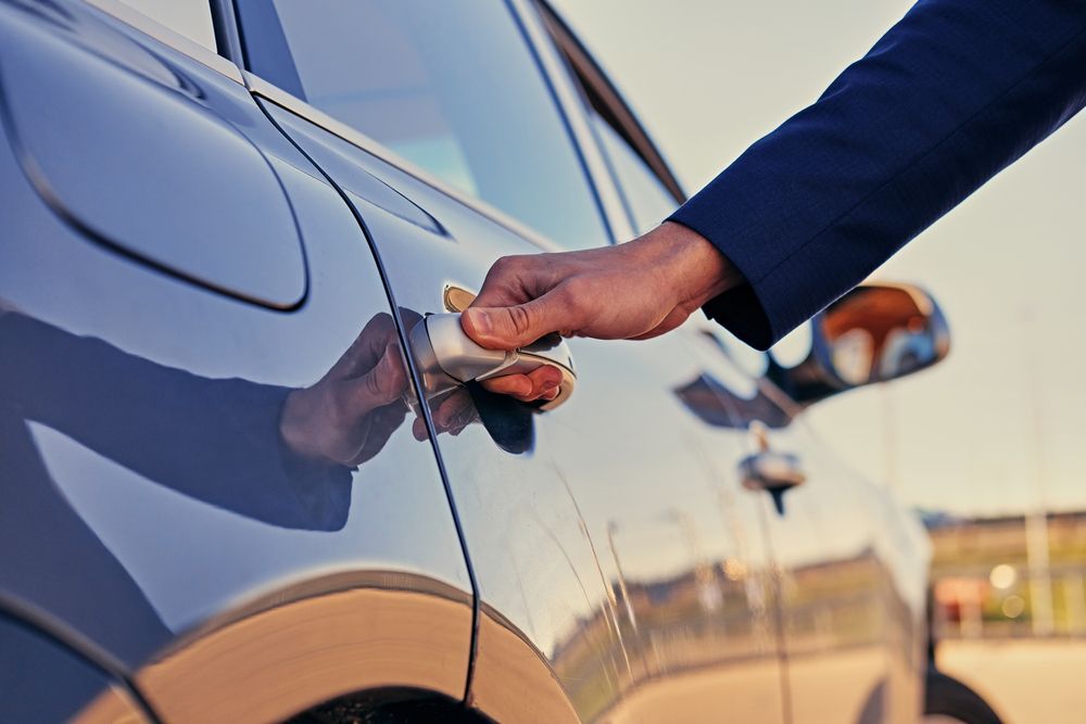 Person’s Hand to Open the Handle of a Sleek, Dark Blue Car — Murwillumbah Motor Wreckers in Lismore, NSW
