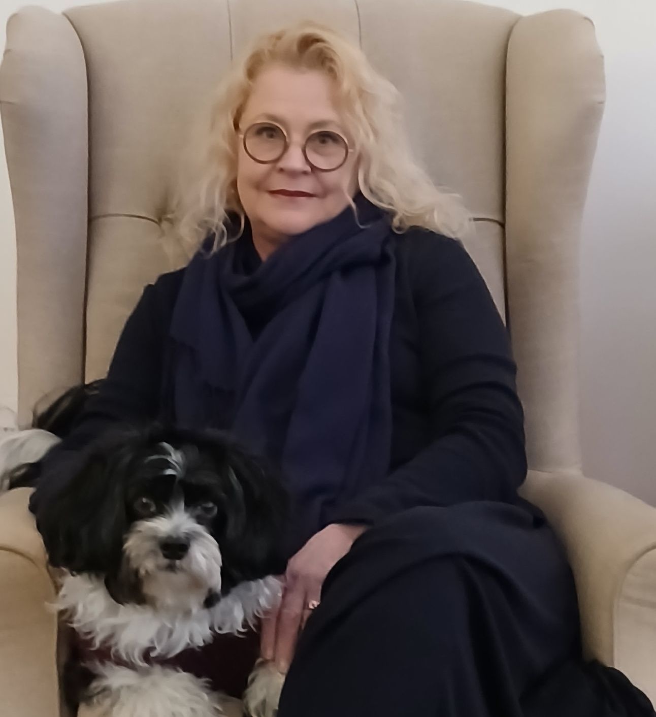 A woman is sitting in a chair with her dog