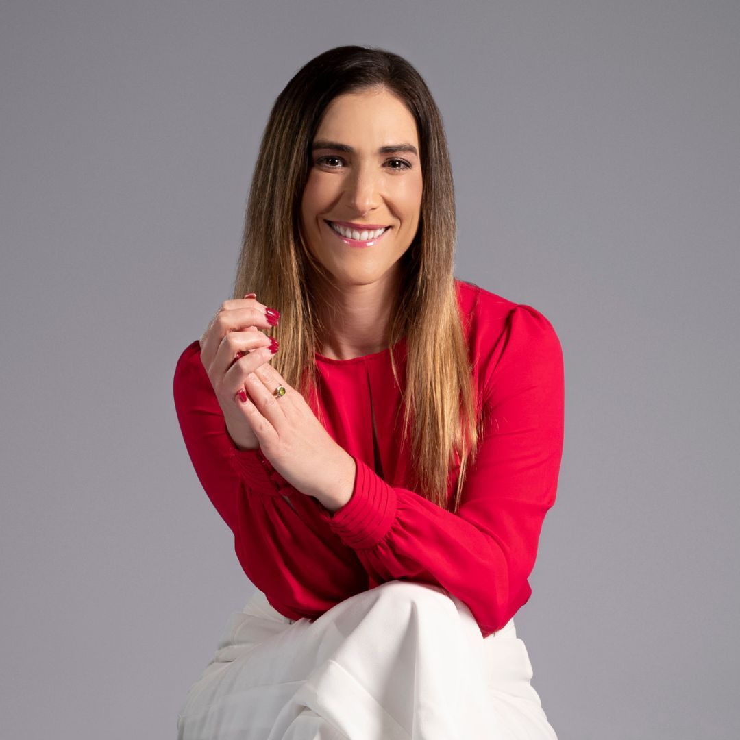 A women in a suit and tie is smiling for the camera