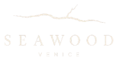 Logo di Seaweed Venice in beige chiaro su sfondo bianco con una linea ondulata stilizzata sopra.