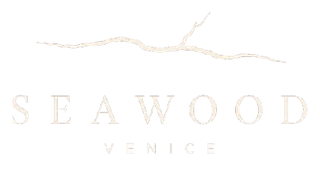 Logo di Seaweed Venice in beige chiaro su sfondo bianco con una linea ondulata stilizzata sopra.