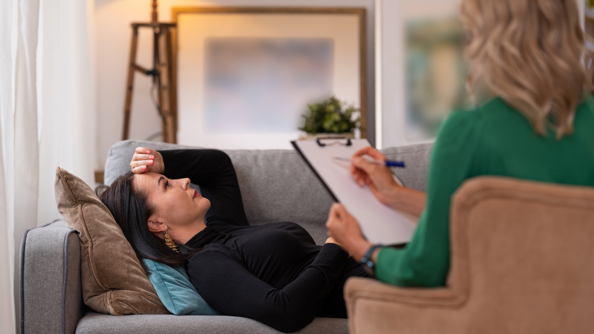 Woman reclining on couch talking to therapist.