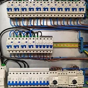 Electrical breaker panel with rows of white circuit breakers and neatly routed blue and black wires