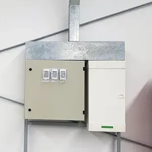 Wall-mounted electrical breaker panels with gray and white metal boxes and three switches.