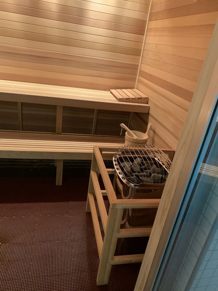 A wooden sauna with a wooden bench and a wooden heater.