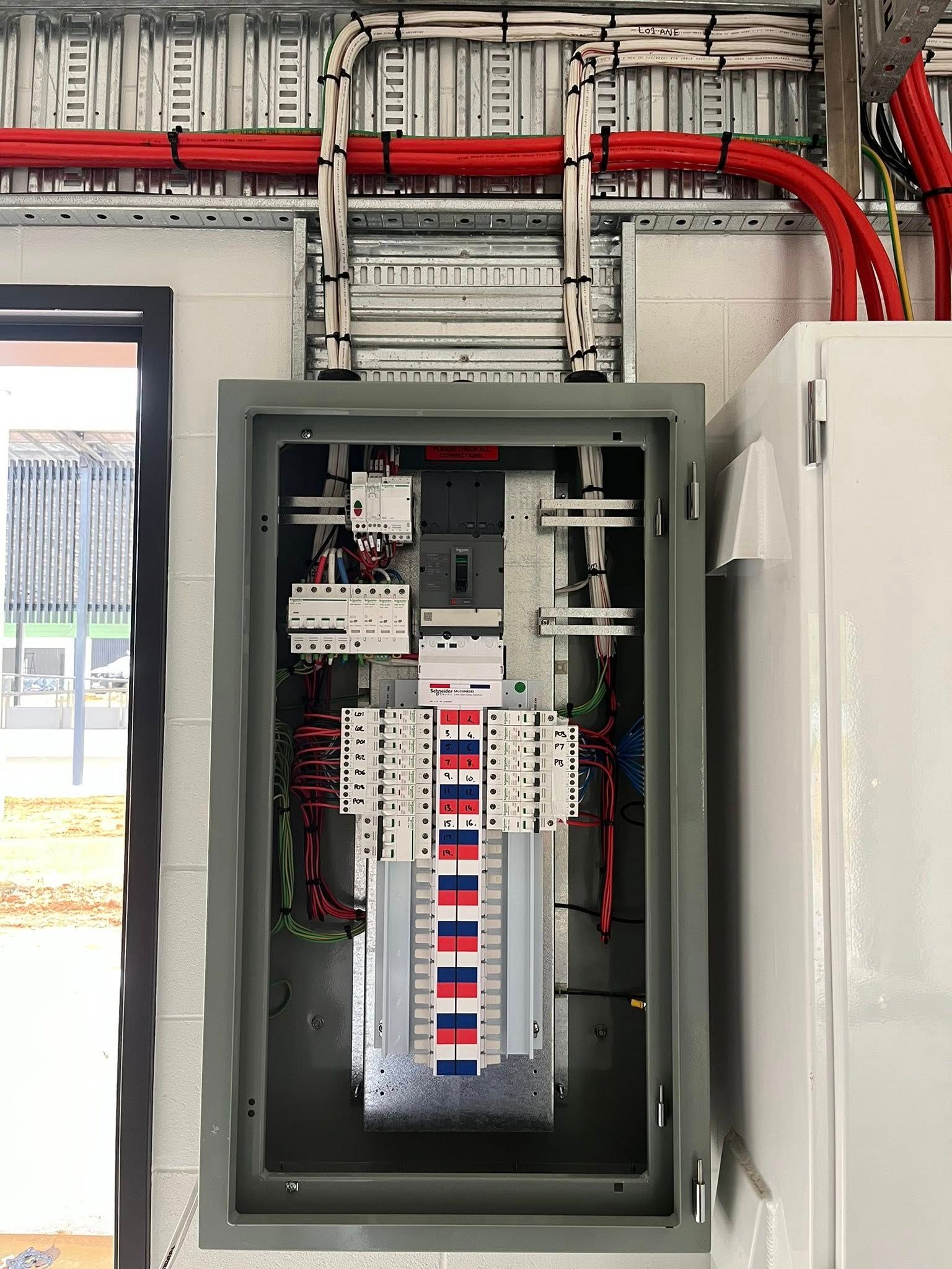 Gloved Hands Working on Electrical Control Panel With Relays and Wiring — Top Spark Electrical FNQ in Mareeba, QLD