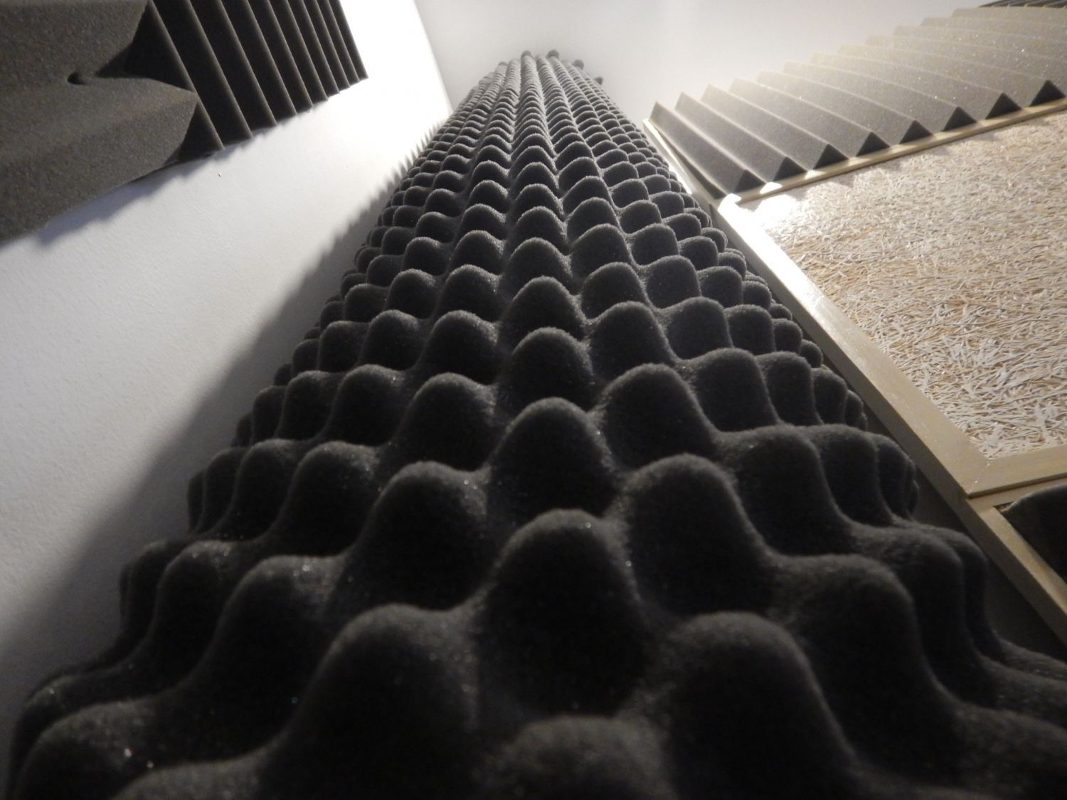 Eine Reihe schwarzer Schaumstoffplatten vor einer weißen Wand