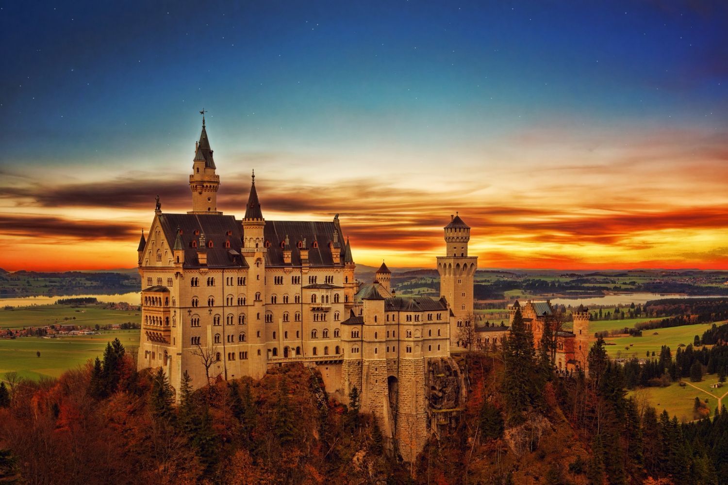 Eine große Burg auf einem Hügel bei Sonnenuntergang.