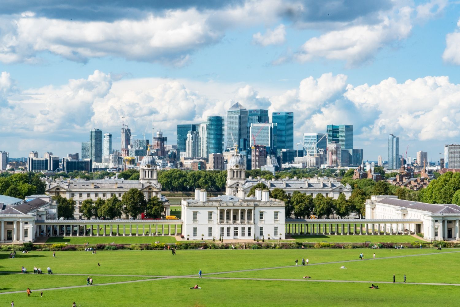 Eine Luftaufnahme der Skyline einer Stadt mit einem großen weißen Gebäude im Vordergrund.