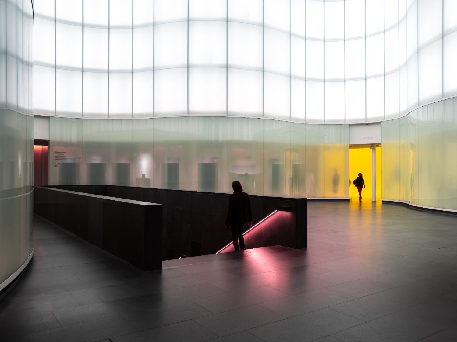 Eine Person geht in einem Gebäude eine Treppe hinunter.