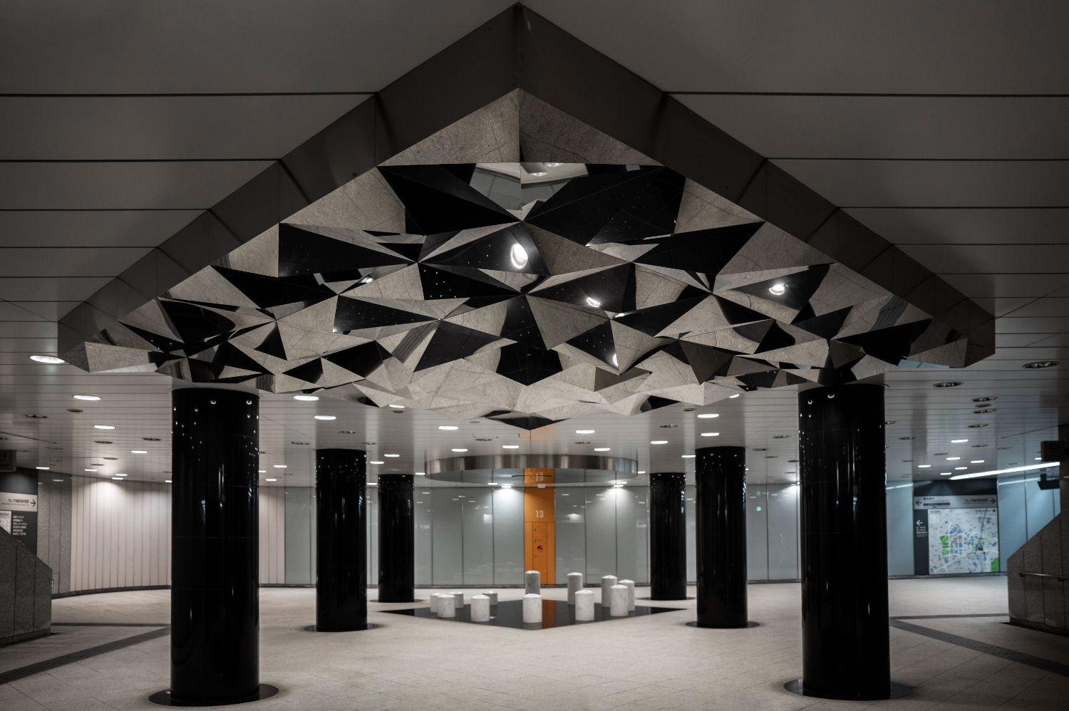 Ein Raum mit Säulen und einer Decke mit geometrischen Formen