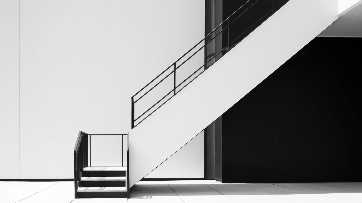Ein Schwarzweißfoto einer Treppe mit einem schwarzen Geländer