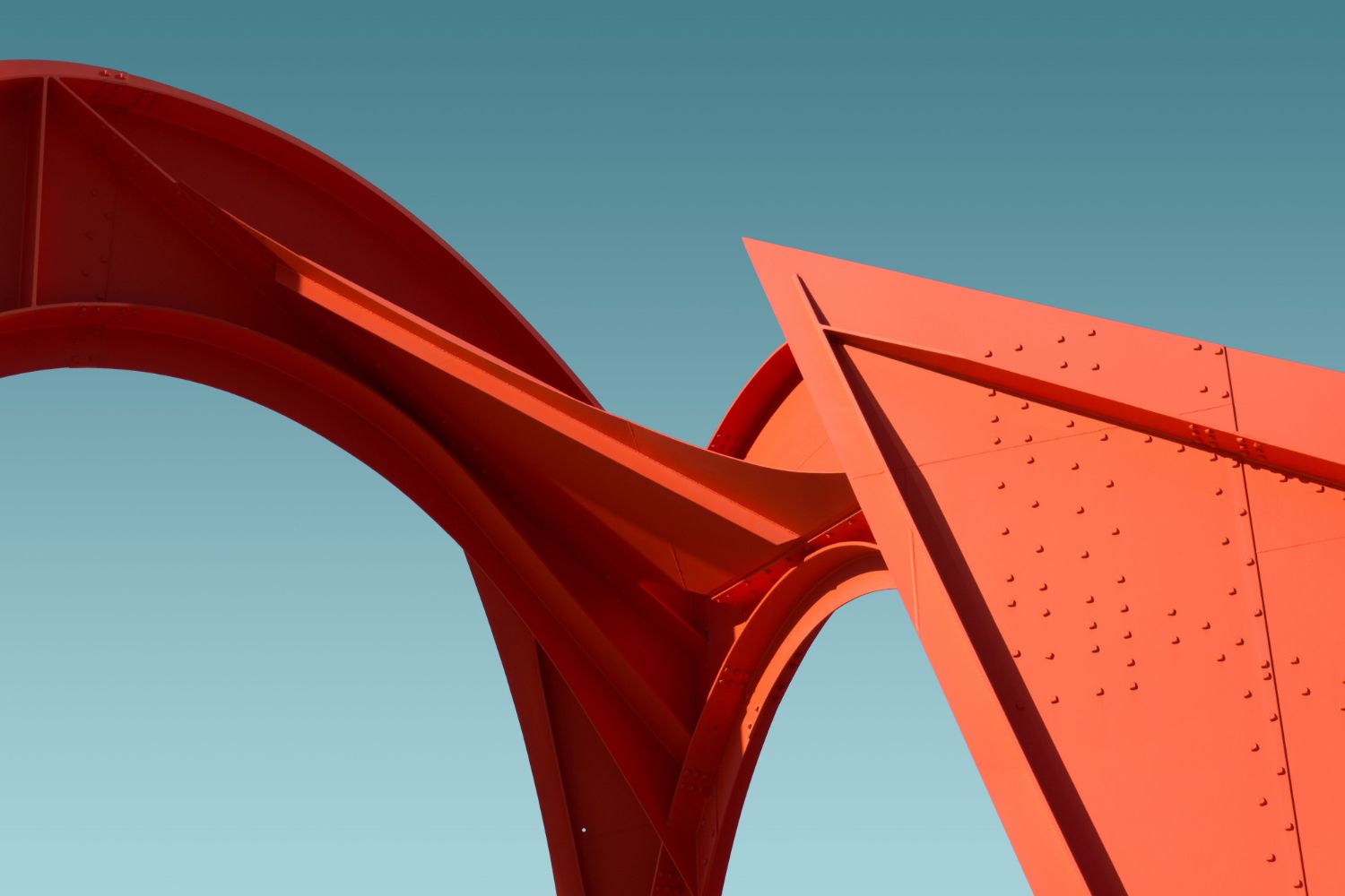 Eine rote Skulptur mit blauem Himmel im Hintergrund