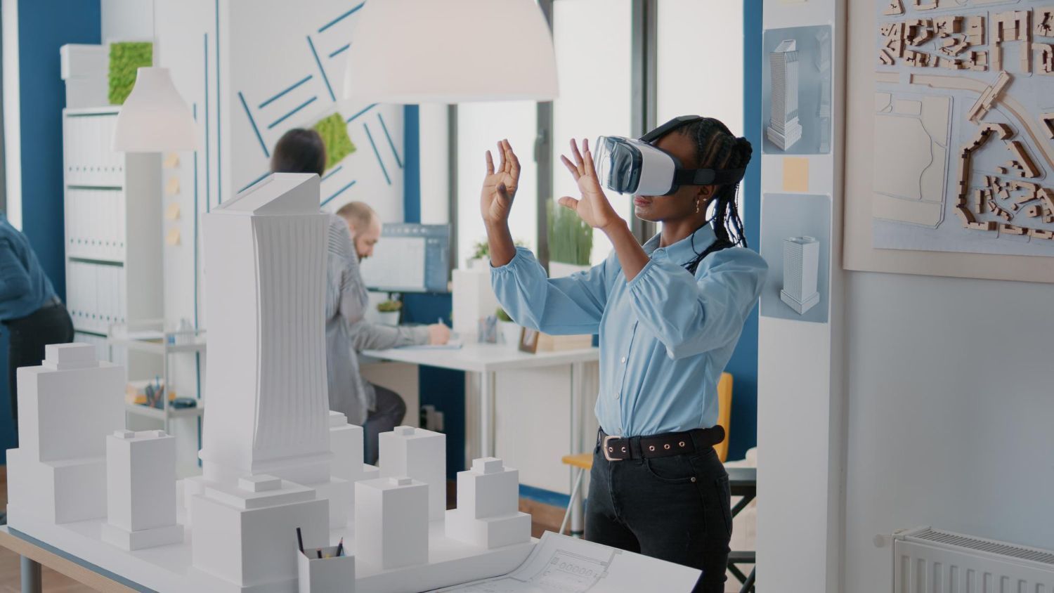 Eine Frau trägt ein Virtual-Reality-Headset, während sie ein Stadtmodell betrachtet.