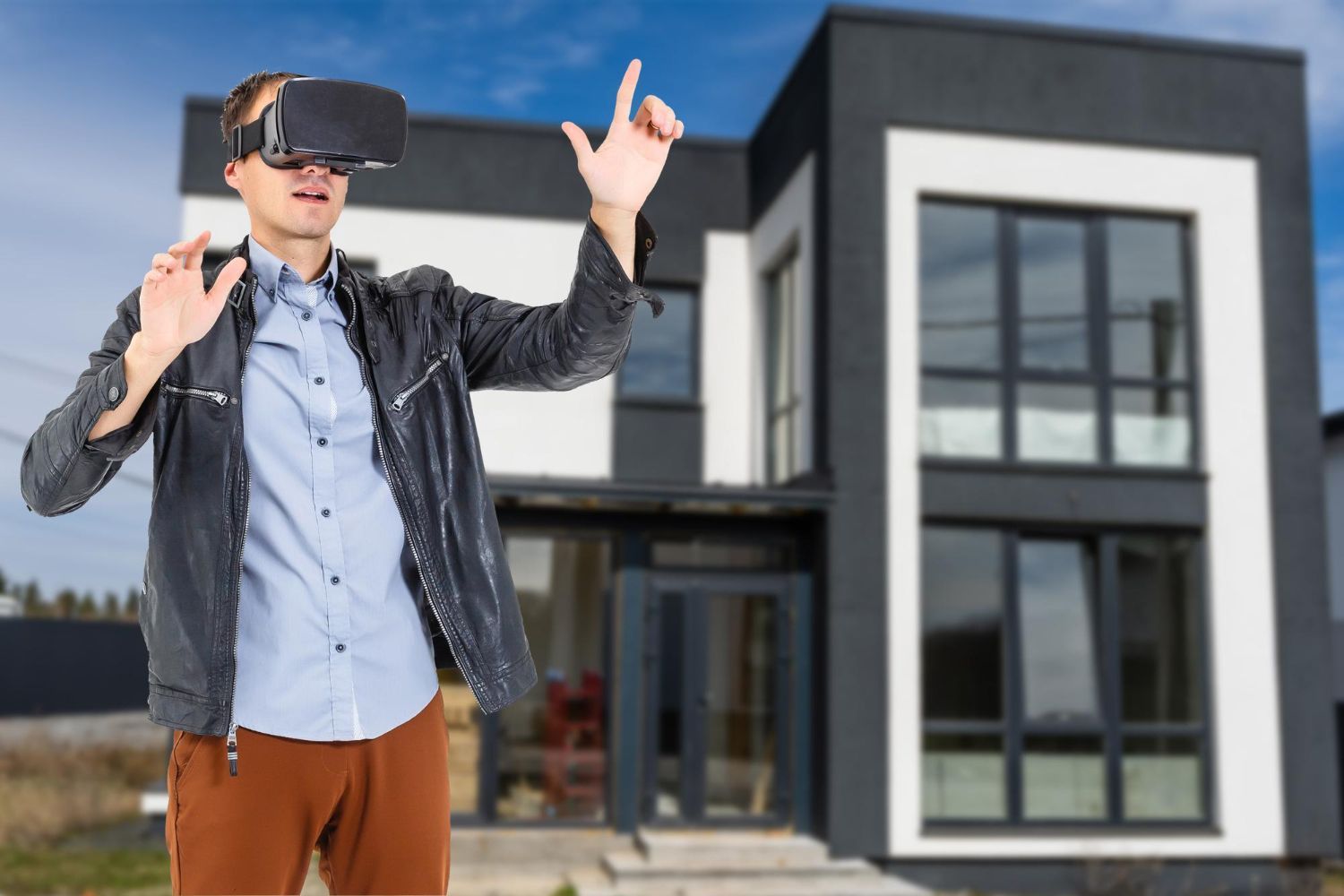 Ein Mann mit einem Virtual-Reality-Headset steht vor einem Haus.