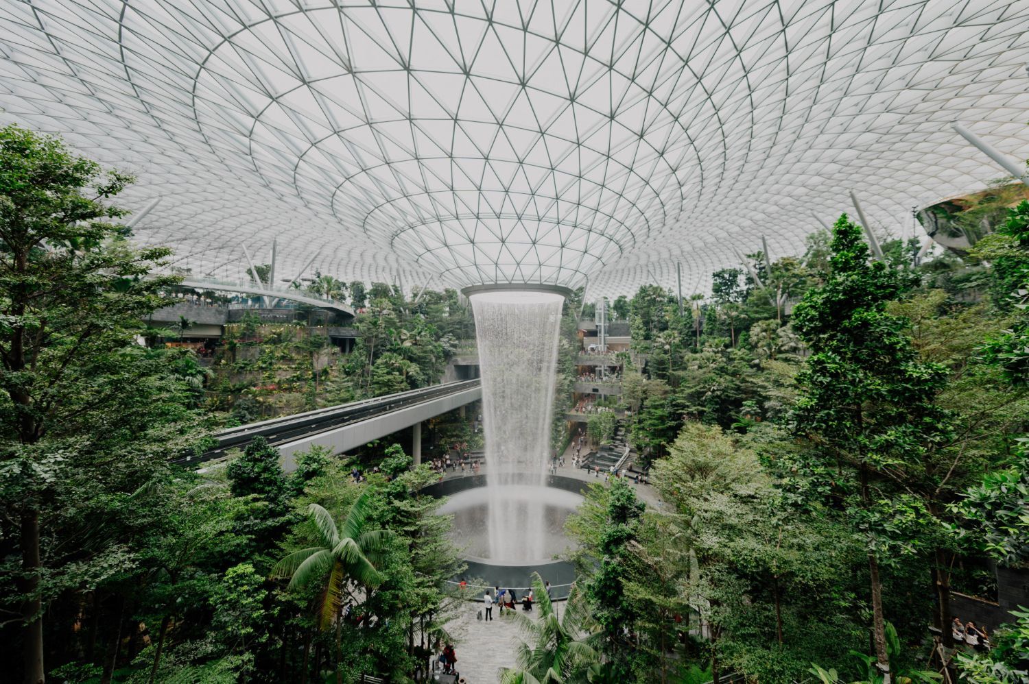 In der Mitte eines von Bäumen umgebenen Gebäudes befindet sich ein Wasserfall.