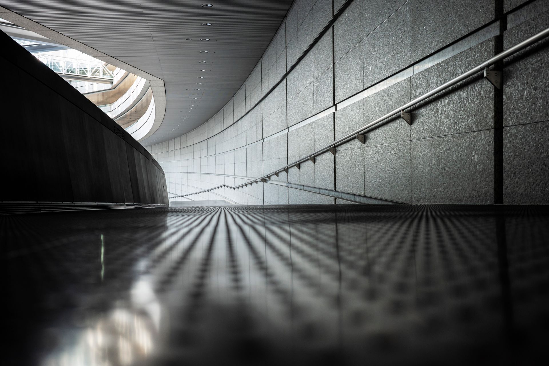 Ein Schwarzweißfoto einer Rolltreppe in einem Gebäude.