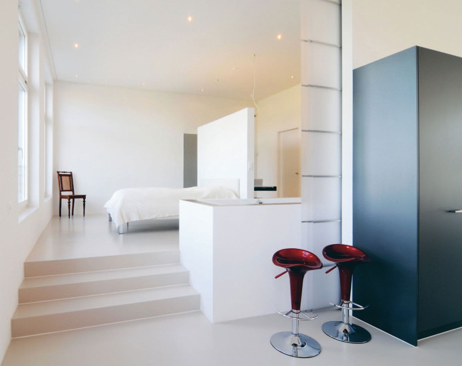 Ein Schlafzimmer mit einem Bett und zwei Barhockern
