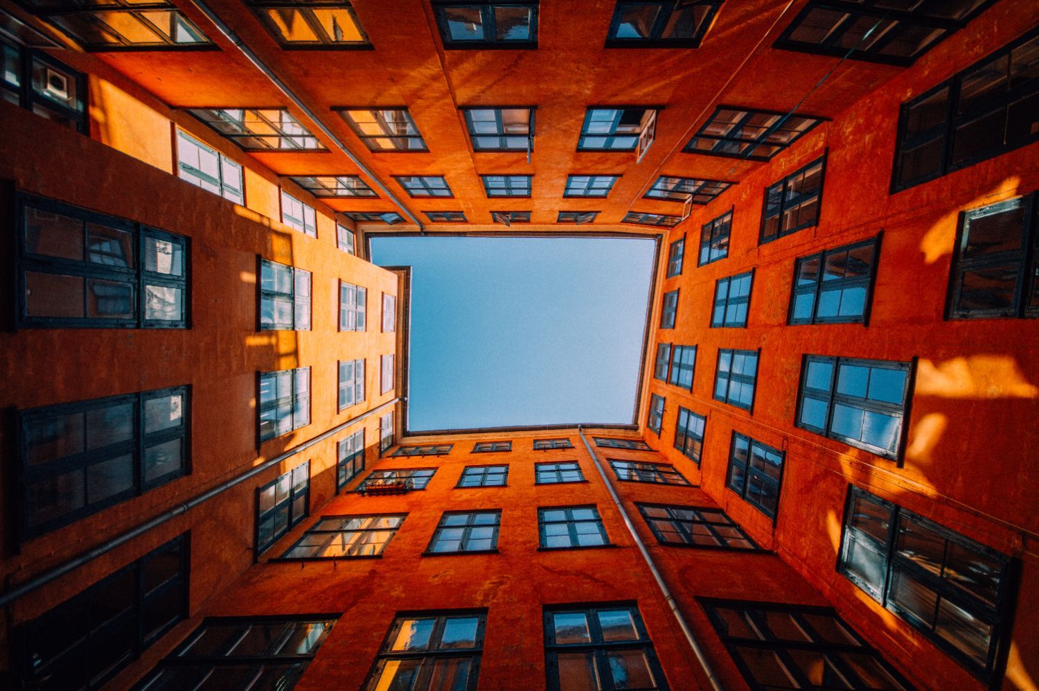 Blick nach oben auf ein Gebäude mit blauem Himmel im Hintergrund.