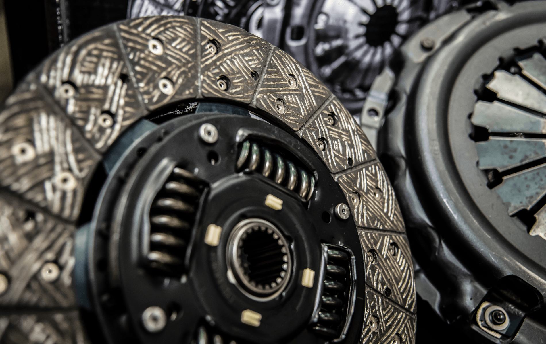 Close-up of automotive clutch discs and pressure plates with metal springs and textured friction surfaces