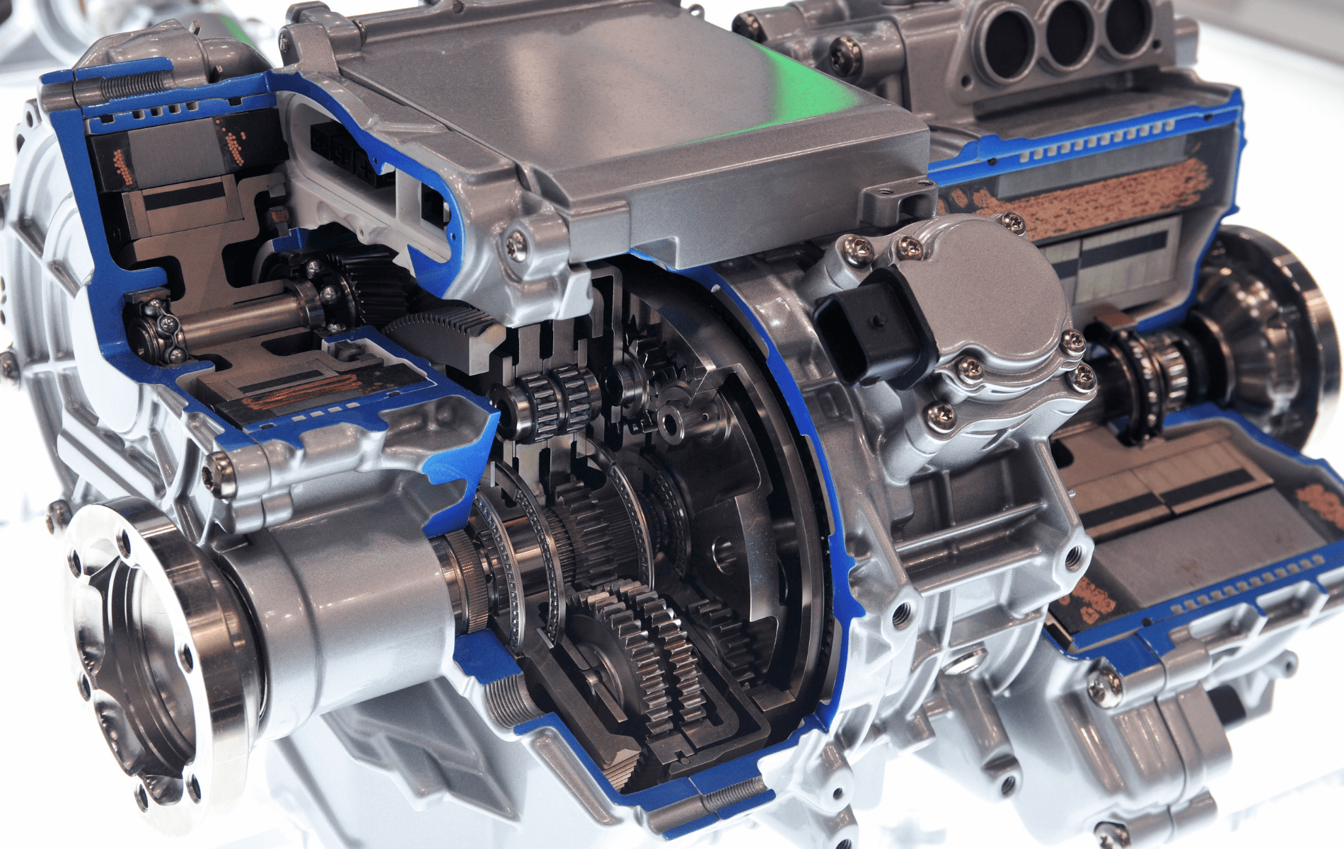 Cutaway of a hybrid car engine with visible blue cooling components and metallic drivetrain parts