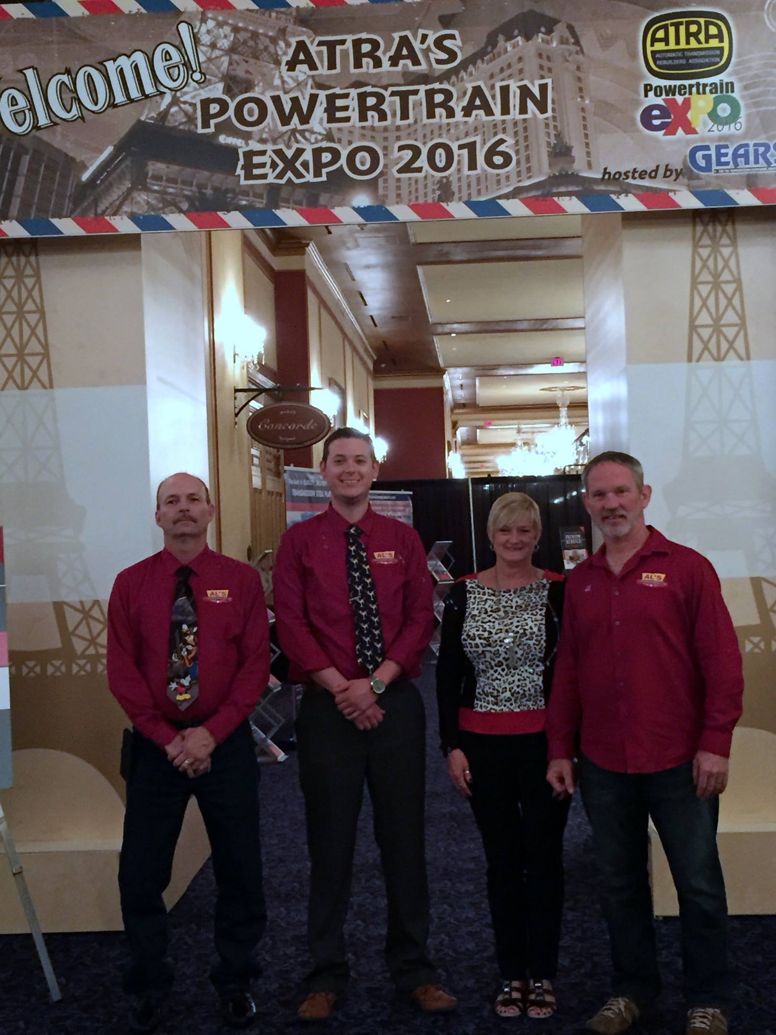 Four people posing in a hotel lobby beneath an ATRA Powertrain Expo 2016 banner.