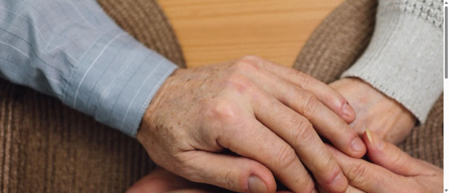 Elderly couple holding hands together for comfort and support