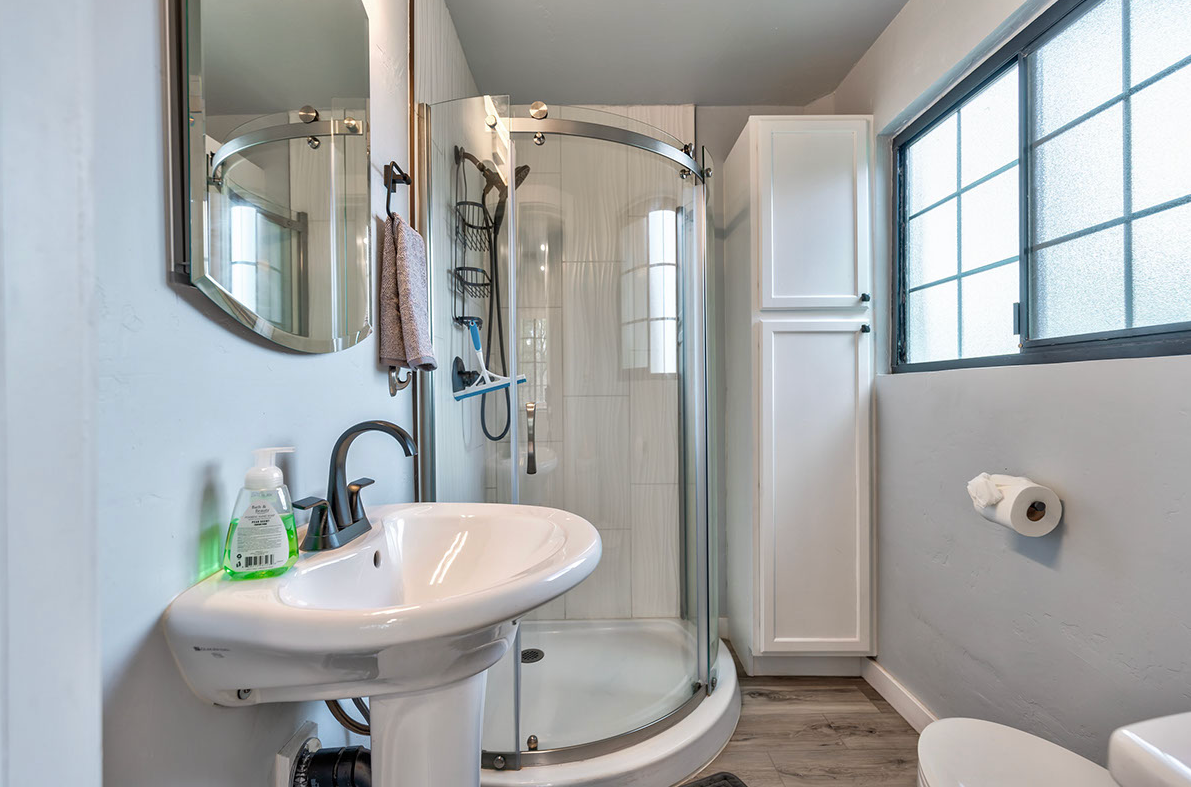 A bathroom with a sink , toilet and shower.