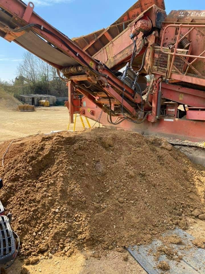A Pile of Dirt Is Being Loaded onto A Conveyor Belt by A Machine — Conveyor Maintenance Services In Innisfail, QLD