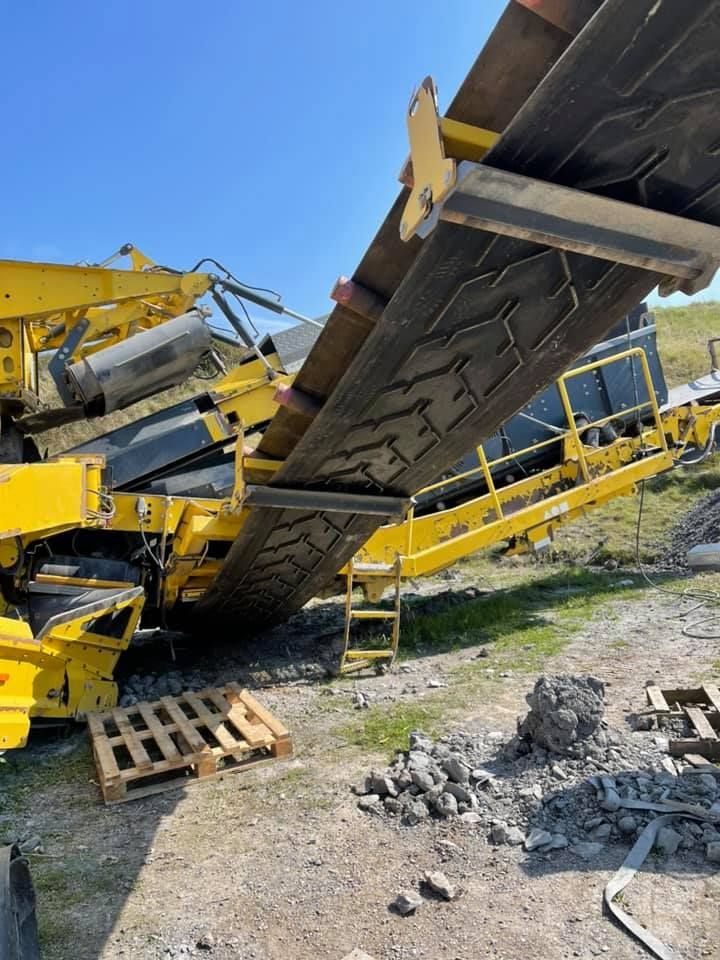 A Large Yellow Machine Is Sitting on Top of A Dirt Field — Conveyor Maintenance Services In Innisfail, QLD
