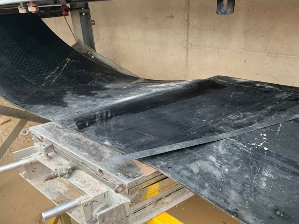 A Black Conveyor Belt Is Sitting on Top of A Metal Structure — Conveyor Maintenance Services In Charters Towers, QLD
