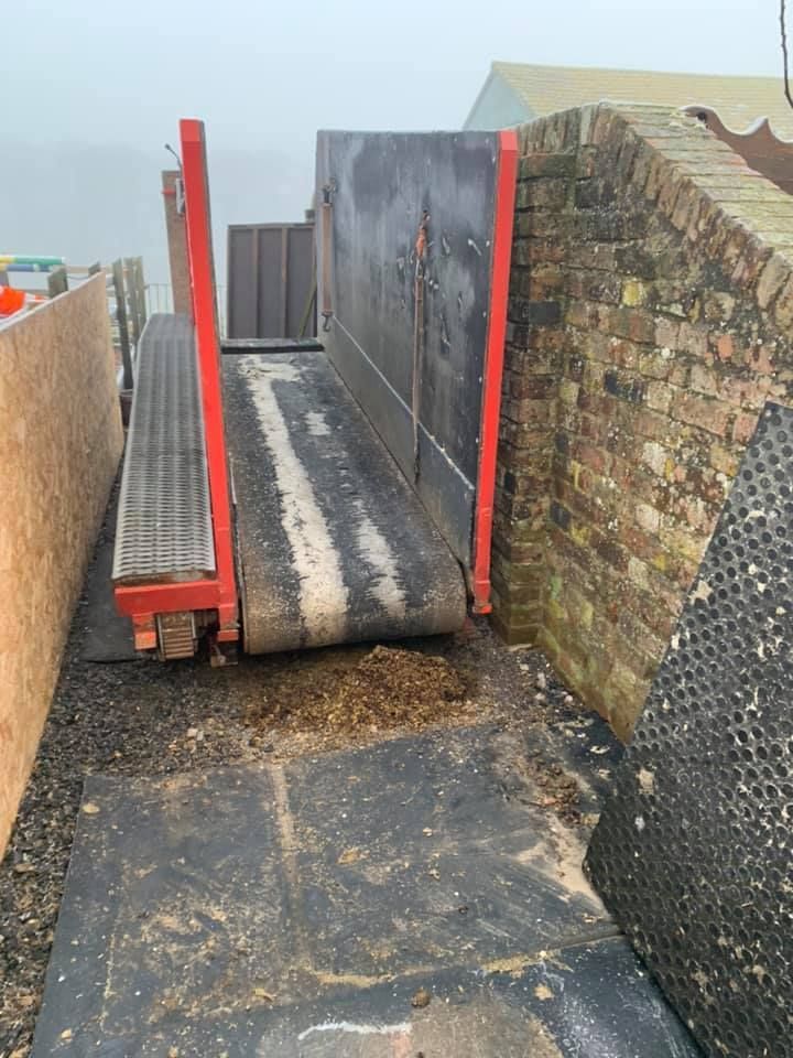 A Conveyor Belt Is Sitting Next to A Brick Wall — Conveyor Maintenance Services In Proserpine, QLD