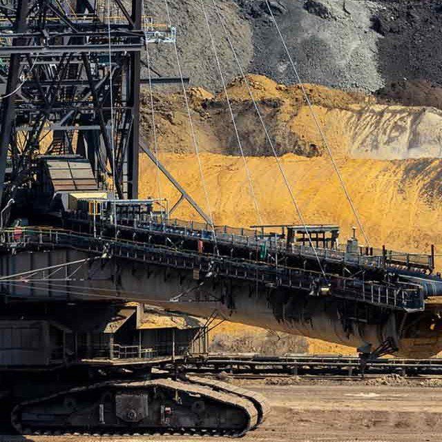 A Large Excavator Is Sitting in The Middle of A Dirt Field — Conveyor Maintenance Services In Ingham, QLD