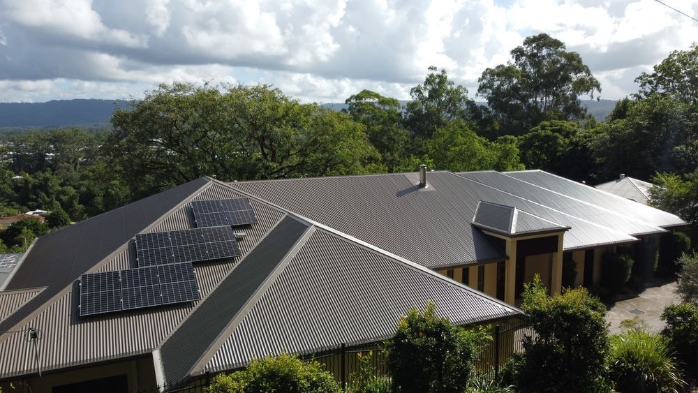 An Aerial View Of A House With Solar Panels On The Roof — Posty’s Roofing In Airlie Beach, QLD