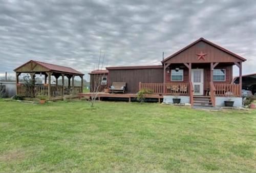 a mobile home with a porch and gazebo in front of it .