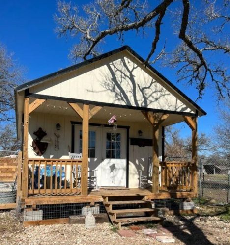 a small white house with a porch and stairs