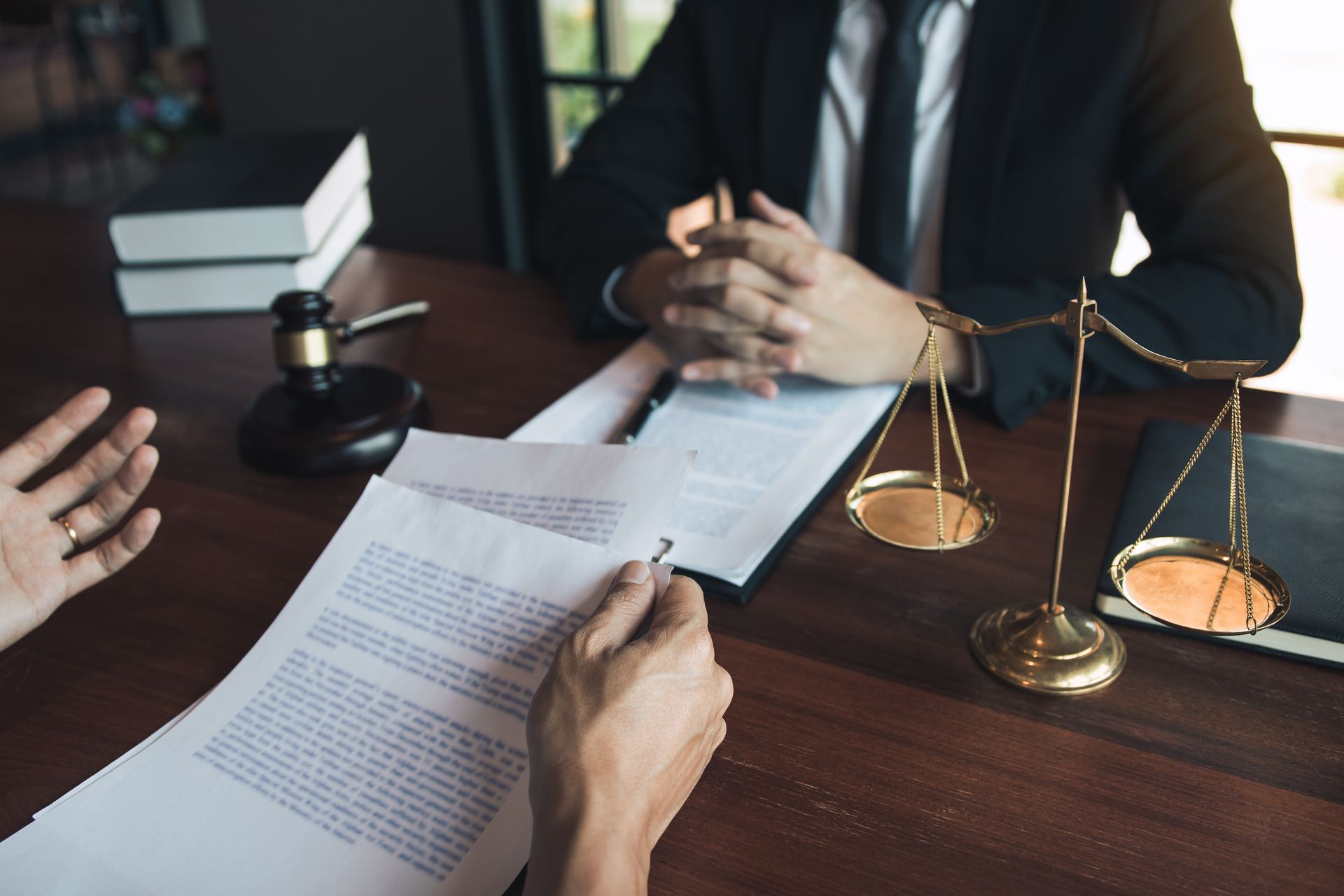 Lawyers reviewing a contract at a desk with a gavel and scales of justice