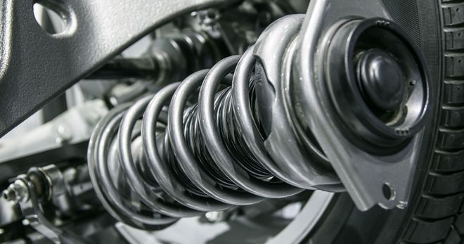 A close up of a shock absorber on a car. A close up of a shock absorber on a car.