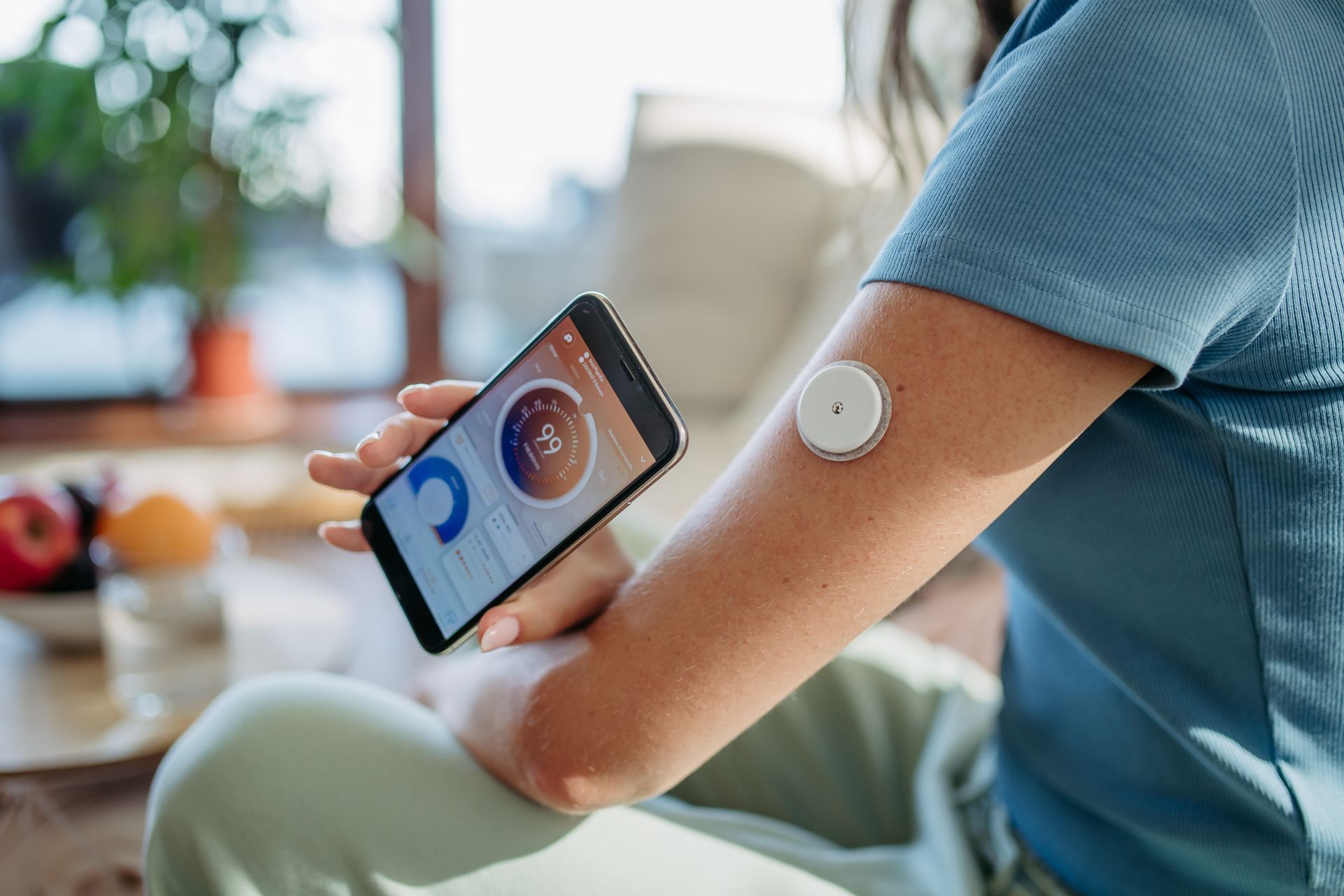 A woman is using a smart device on her arm.