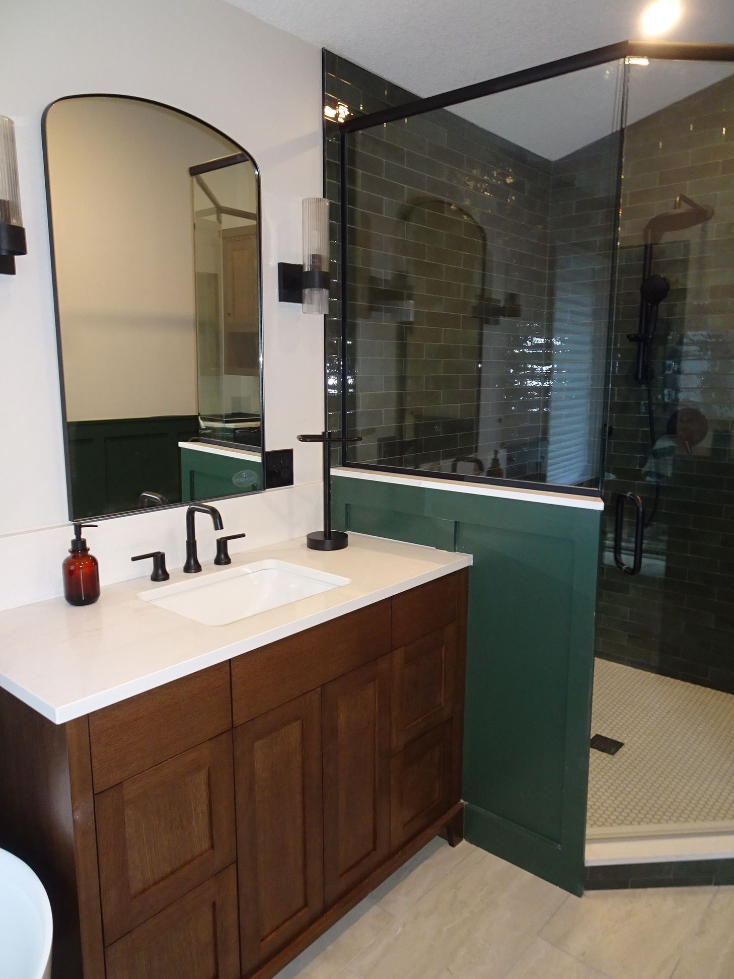 Glass shower enclosure with black metal frame and arched mirror, primary bathroom remodel, Eden Prairie, MN